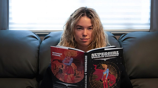 Милли Олкок изучает комиксы на съёмках «Супергёрл»
